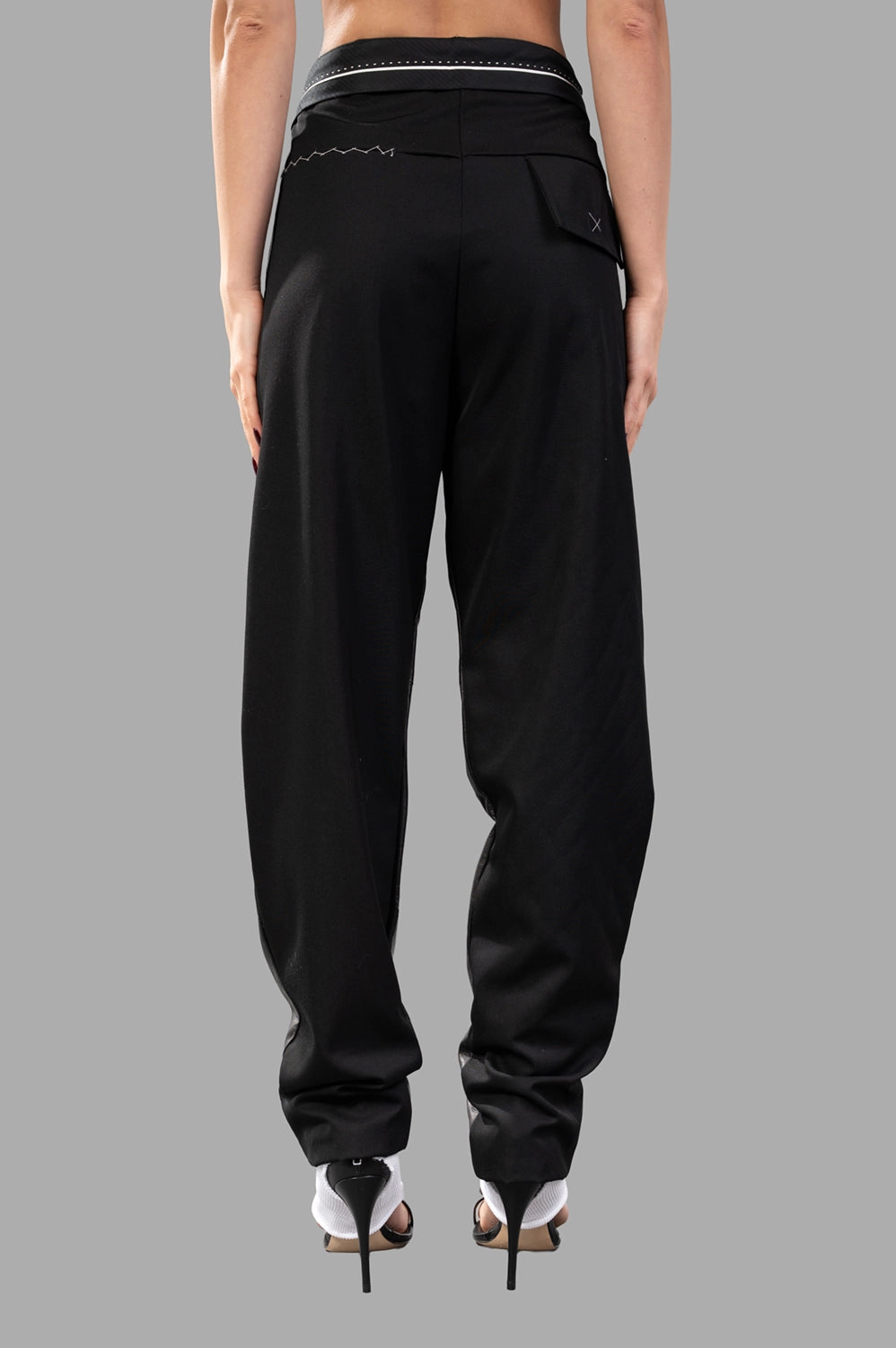 Back view close-up with matte fabric, contrast stitching at yoke and draped leg