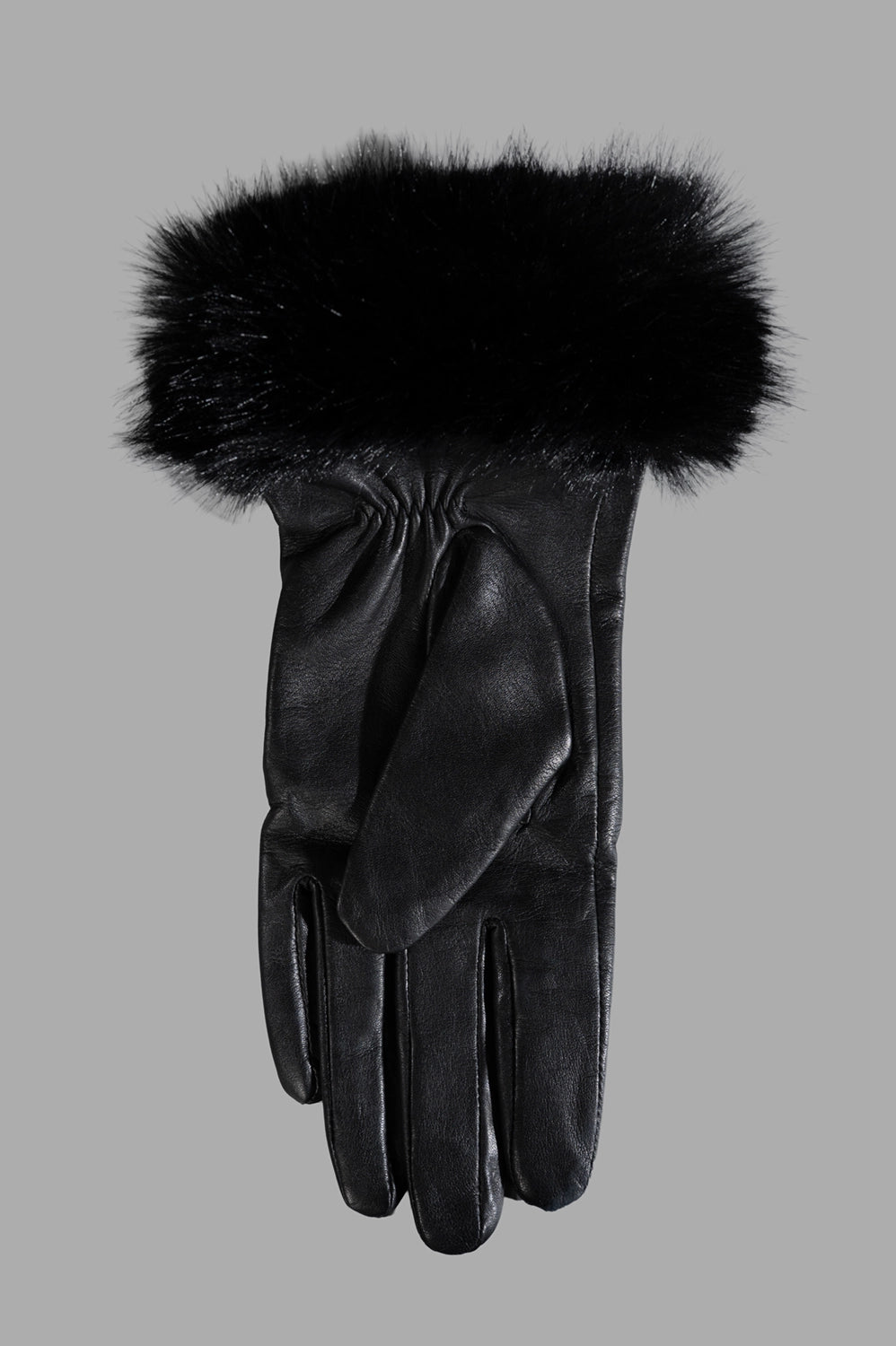 Close-up of black leather glove showing plush faux-fur cuff and smooth leather finish