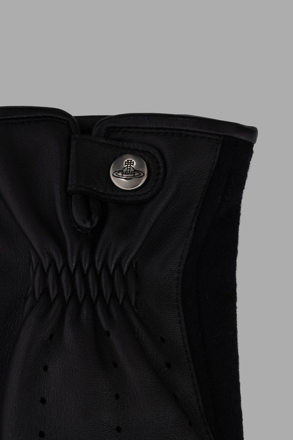 Vivienne Westwood gloves in black, hardware close-up, Orb-logo snap tab at cuff