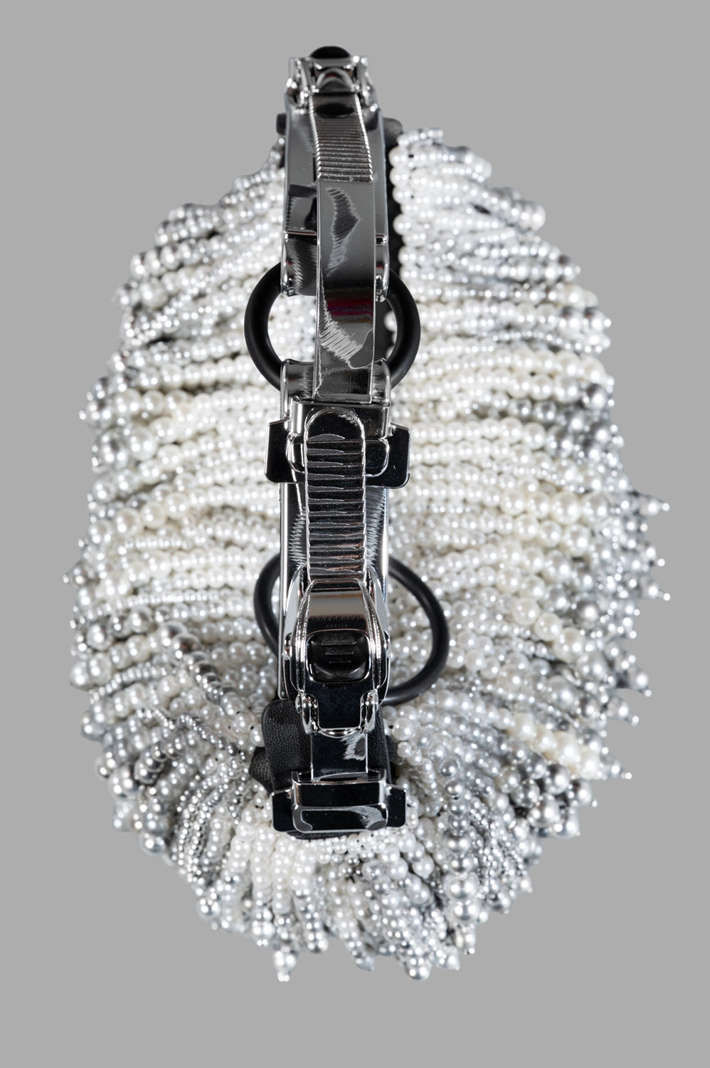 Front close-up showing draped pearl fringe with airbrushed silver gradient, zip opening, and ring detail.