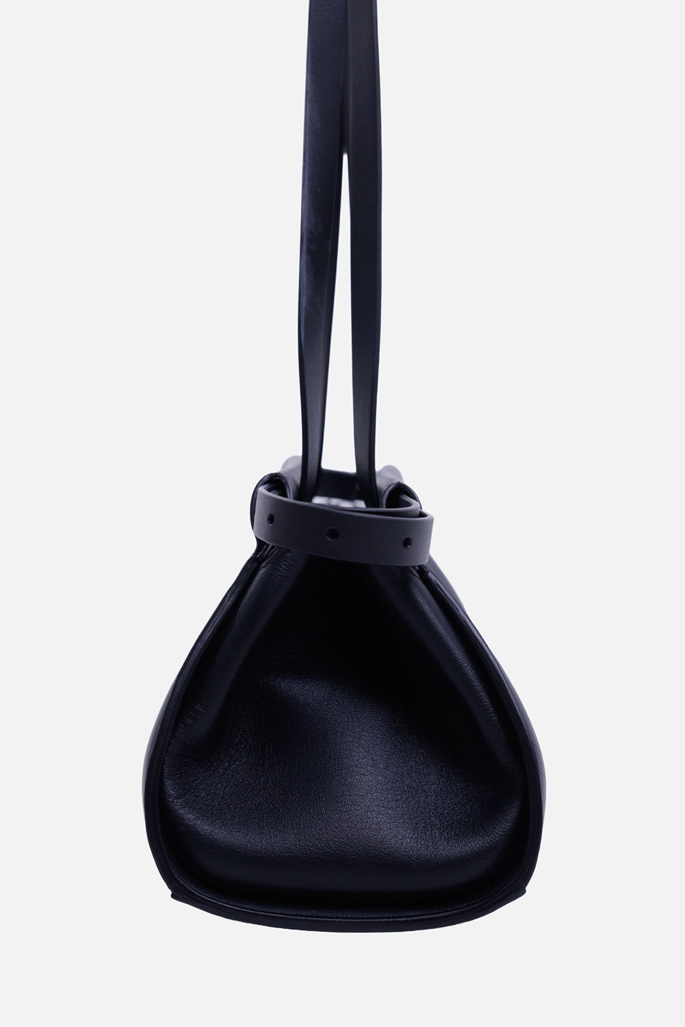Ann Demeulemeester Harm shoulder bag in black, side view with folded gusset and adjustable perforated strap

