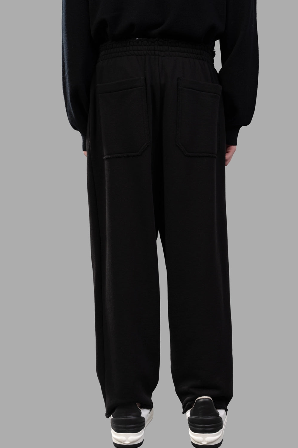 Front close-up of sweatpants waistband with rubber patch and drawstring
