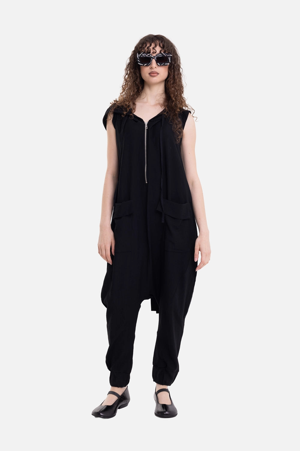 La Haine Inside Us women's hooded jumpsuit in black, on-model full-length view, dropped crotch and cargo pockets