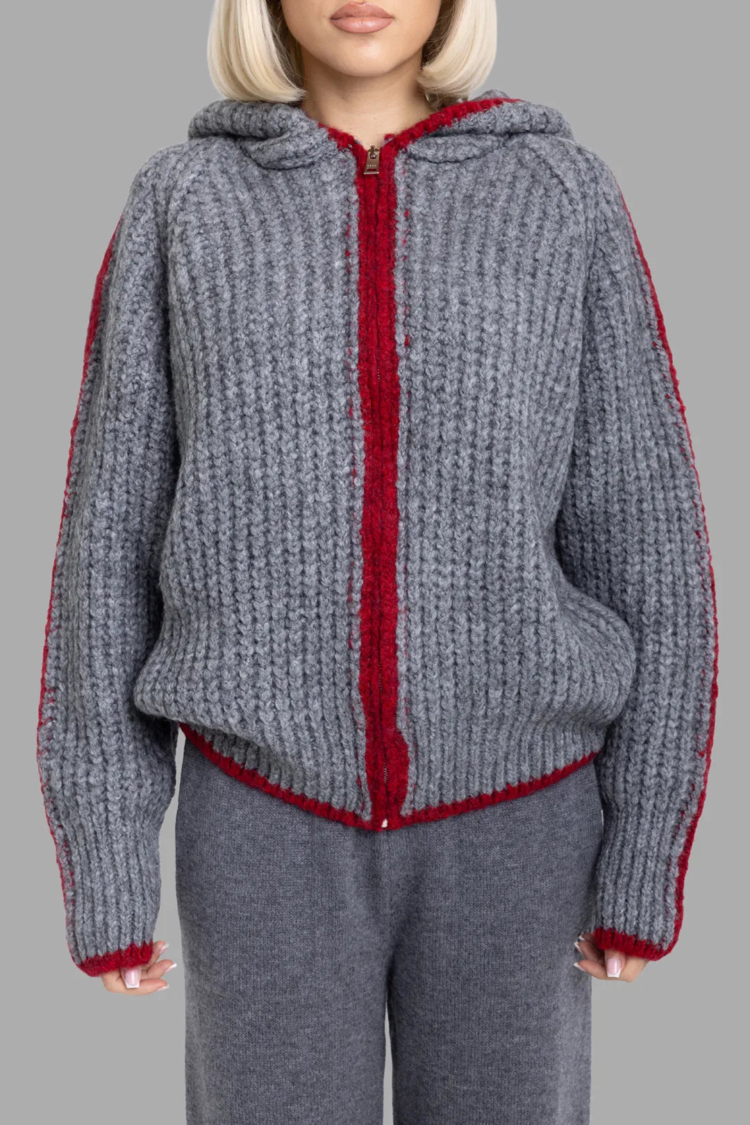 MSGM women's grey hooded knit zip cardigan, front view on model, chunky ribbed texture with red contrast trim at zip and hem.