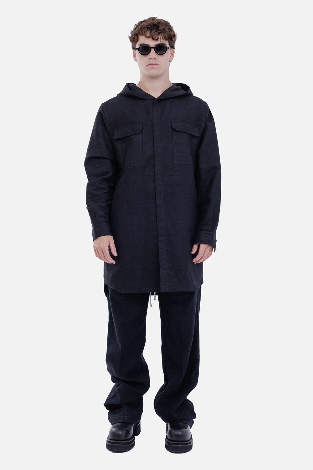 Rick Owens men's black hooded outershirt, full-length on-model view with elongated hem and chest pockets
