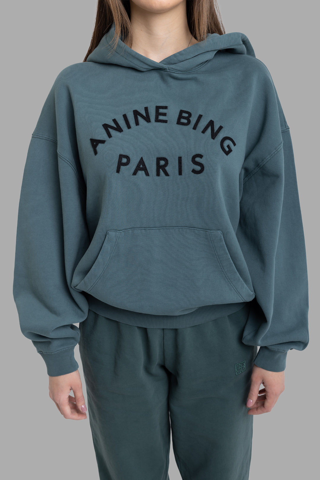 Anine Bing women’s dark teal Harvey Paris hoodie, front view showing arched ANINE BING PARIS logo and ribbed hem