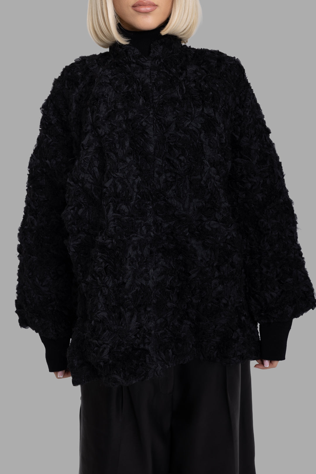 Comme des Garçons women's black textured quilted jacket, front view, 3D floral surface and ribbed knit cuffs.