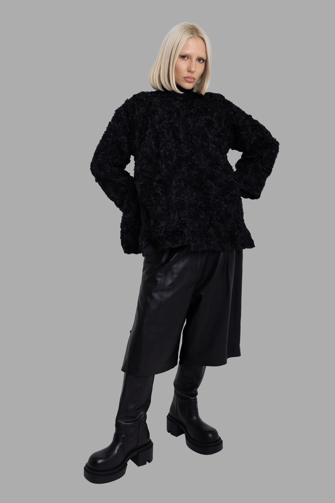 Comme des Garçons women's black textured quilted jacket, on-model full-length, oversized fit with long sleeves.