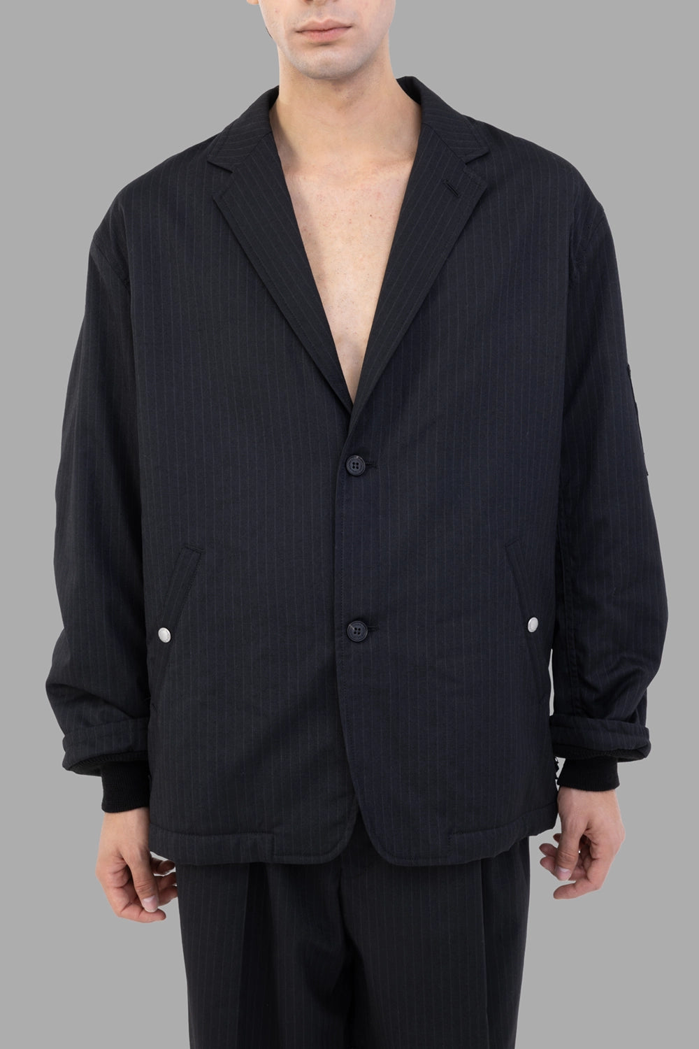 Junya Watanabe jacket in black pinstripe, front view, two-button closure and welt pockets