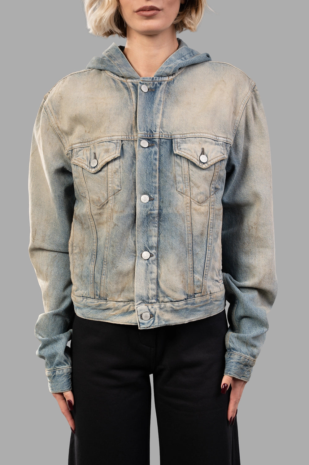 Front close-up of hooded denim jacket showing button closure, flap chest pockets and faded stonewash