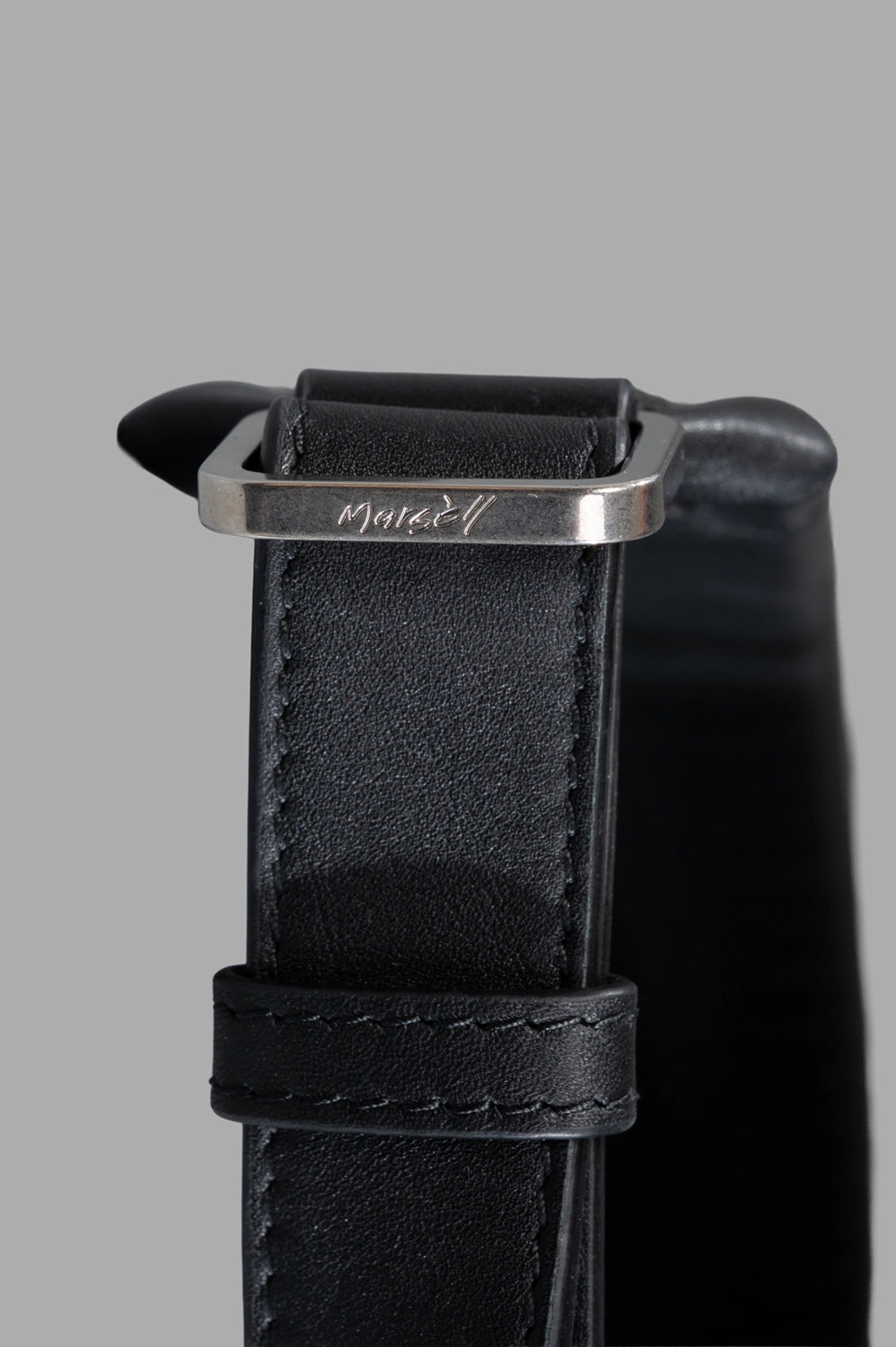 Marsèll laptop bag in black, hardware close-up, engraved buckle on strap