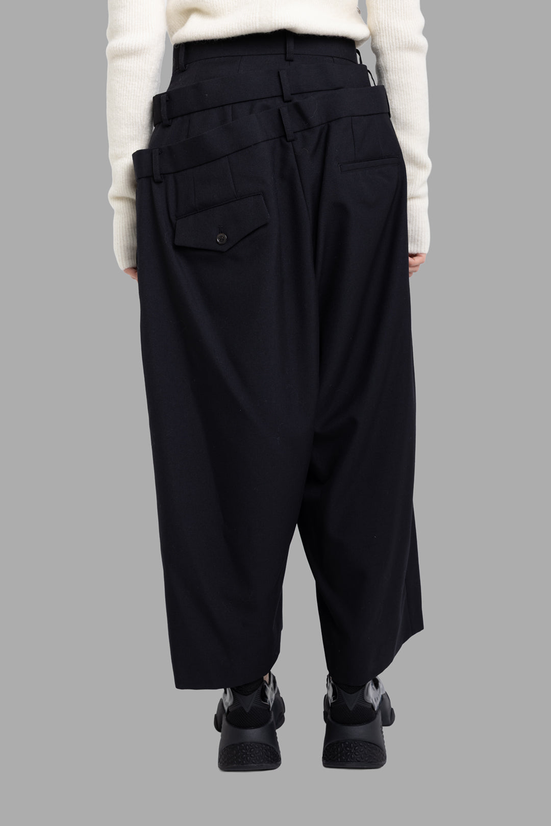 Noir Kei Ninomiya women’s black layered waist trousers, back view with cropped wide leg and buttoned flap pocket