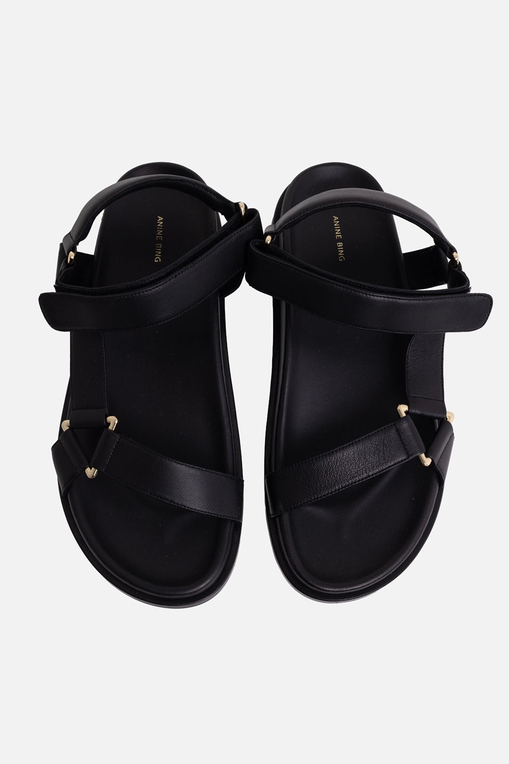 Anine Bing women's leather sandals in black, top view with wide straps, gold hardware and printed insoles