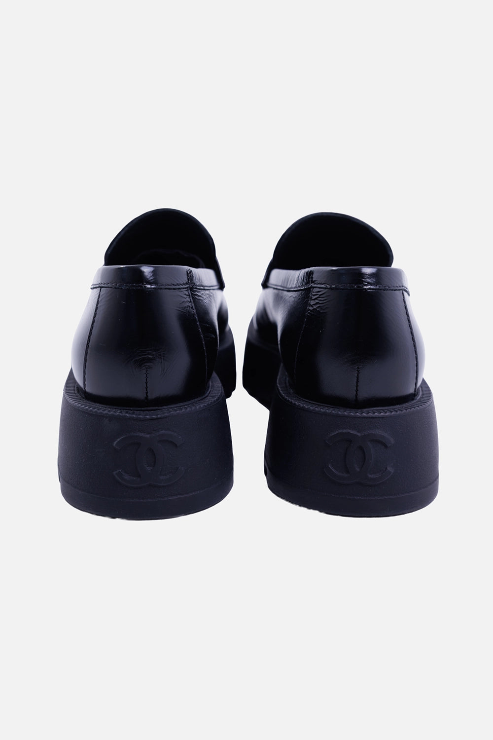 Chanel women's black leather loafers, back view with embossed CC heels and glossy leather uppers

