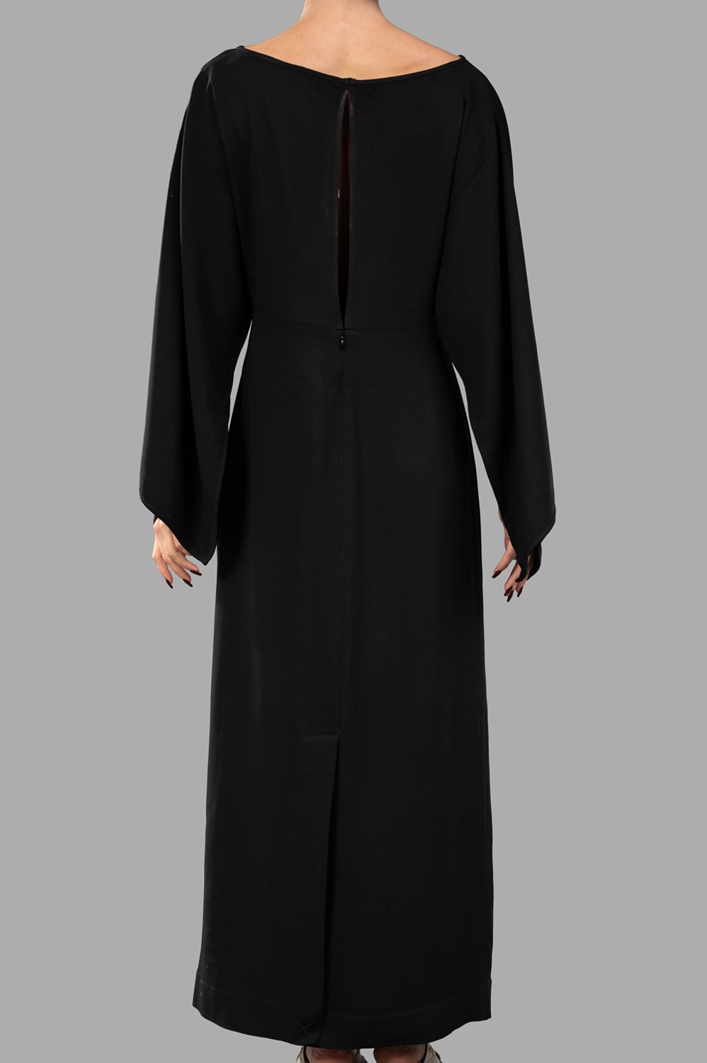 Back view of black maxi dress with slit opening and button closure at neck