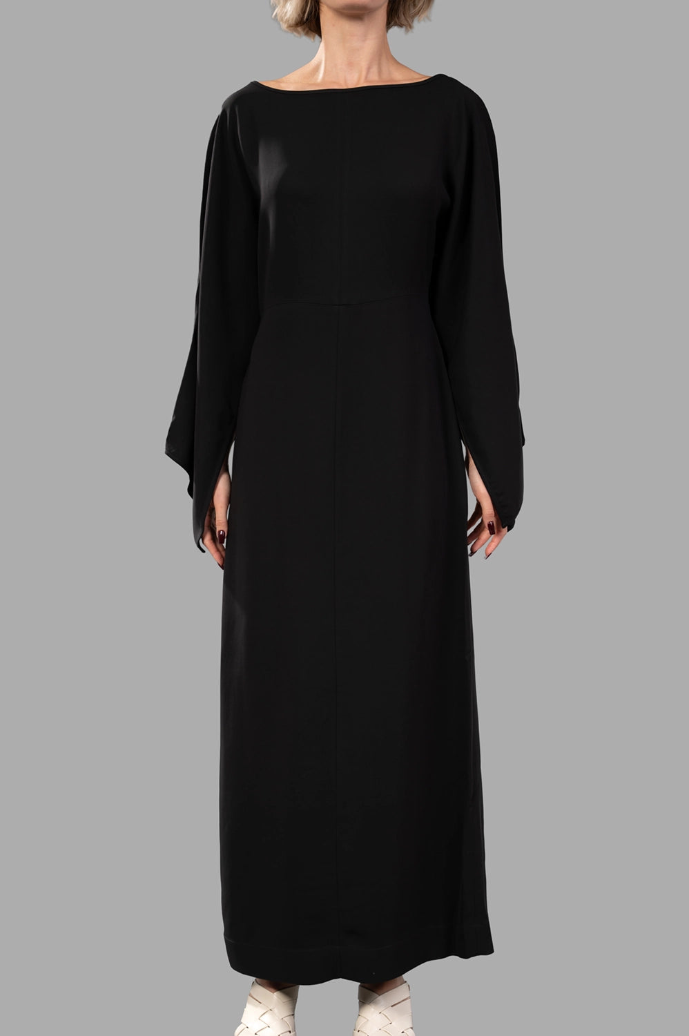Front close-up of black maxi dress showing bateau neckline and draped sleeve detail
