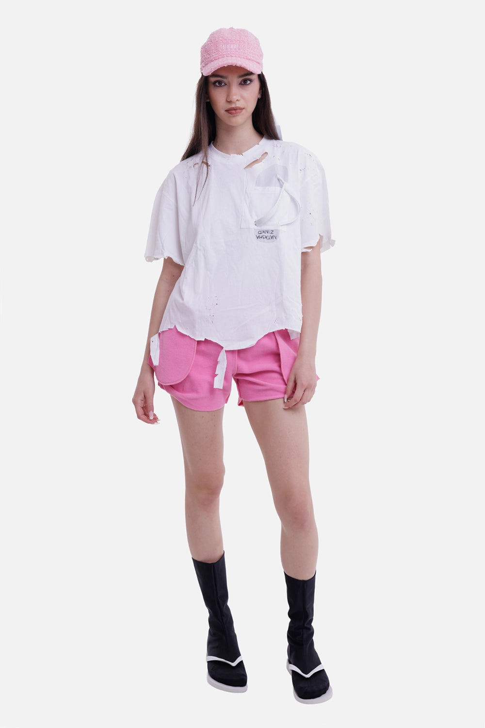 Natasha Zinko women's pink mini shorts, model view with curved side panels and exposed seams
