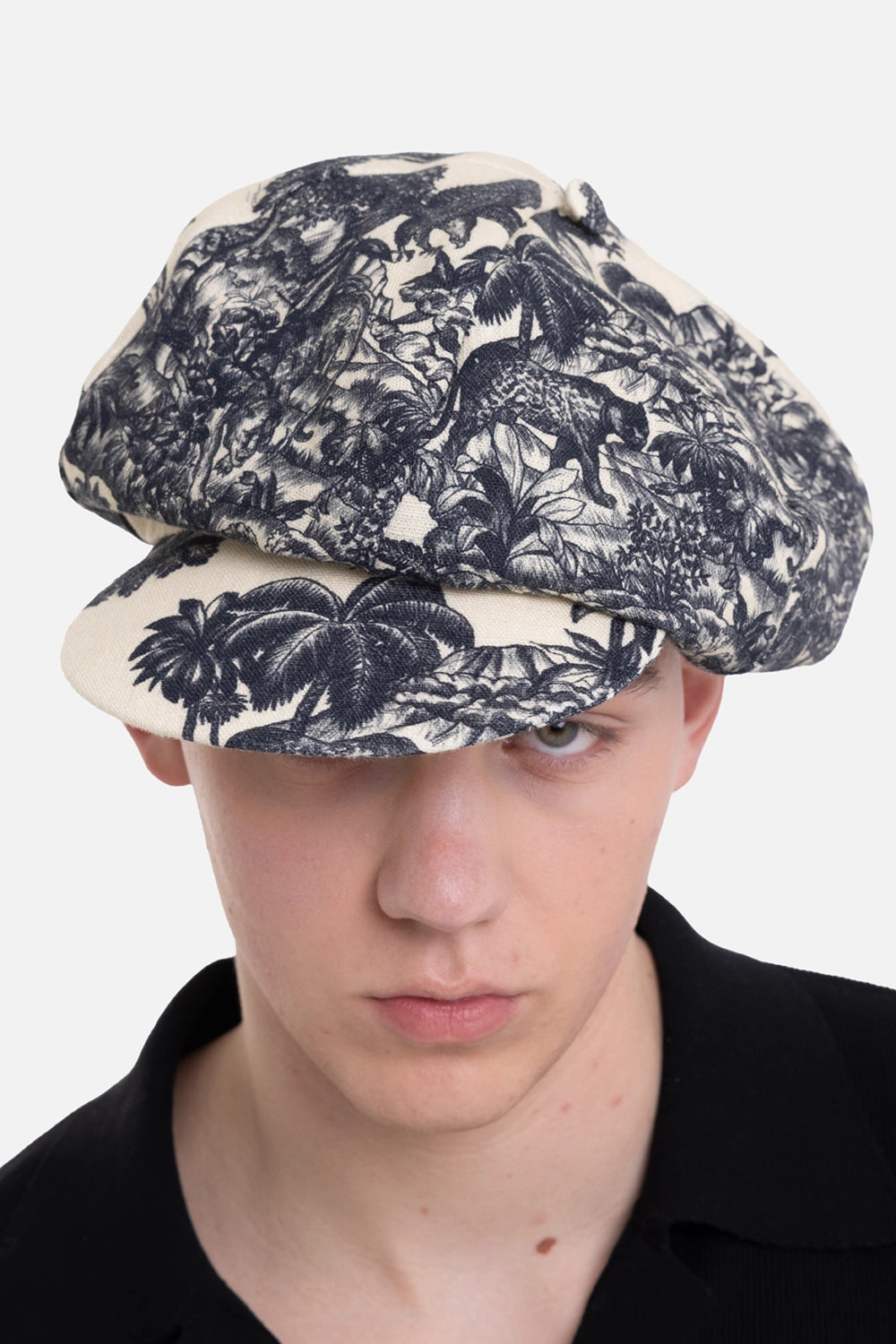 Marc Point men's newsboy cap in natural/black, front view with leopard motif, palm trees and covered top button