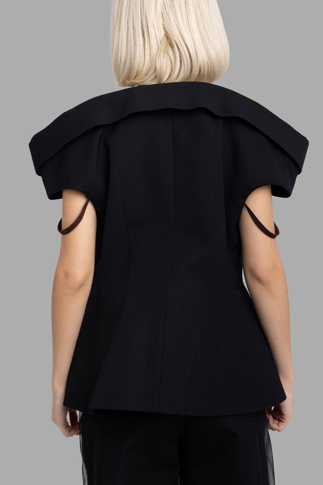 Noir Kei Ninomiya women's black off-shoulder wool blazer, back view showing sculpted folded shoulder panel and flared hem