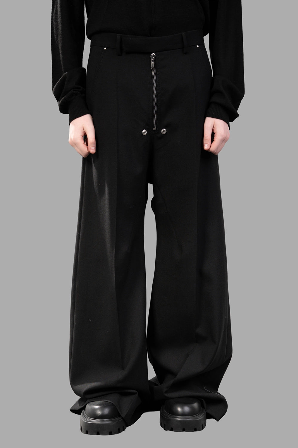Rick Owens wide-leg pants in black wool‑blend, front view, zip and hook closure and hardware rivets