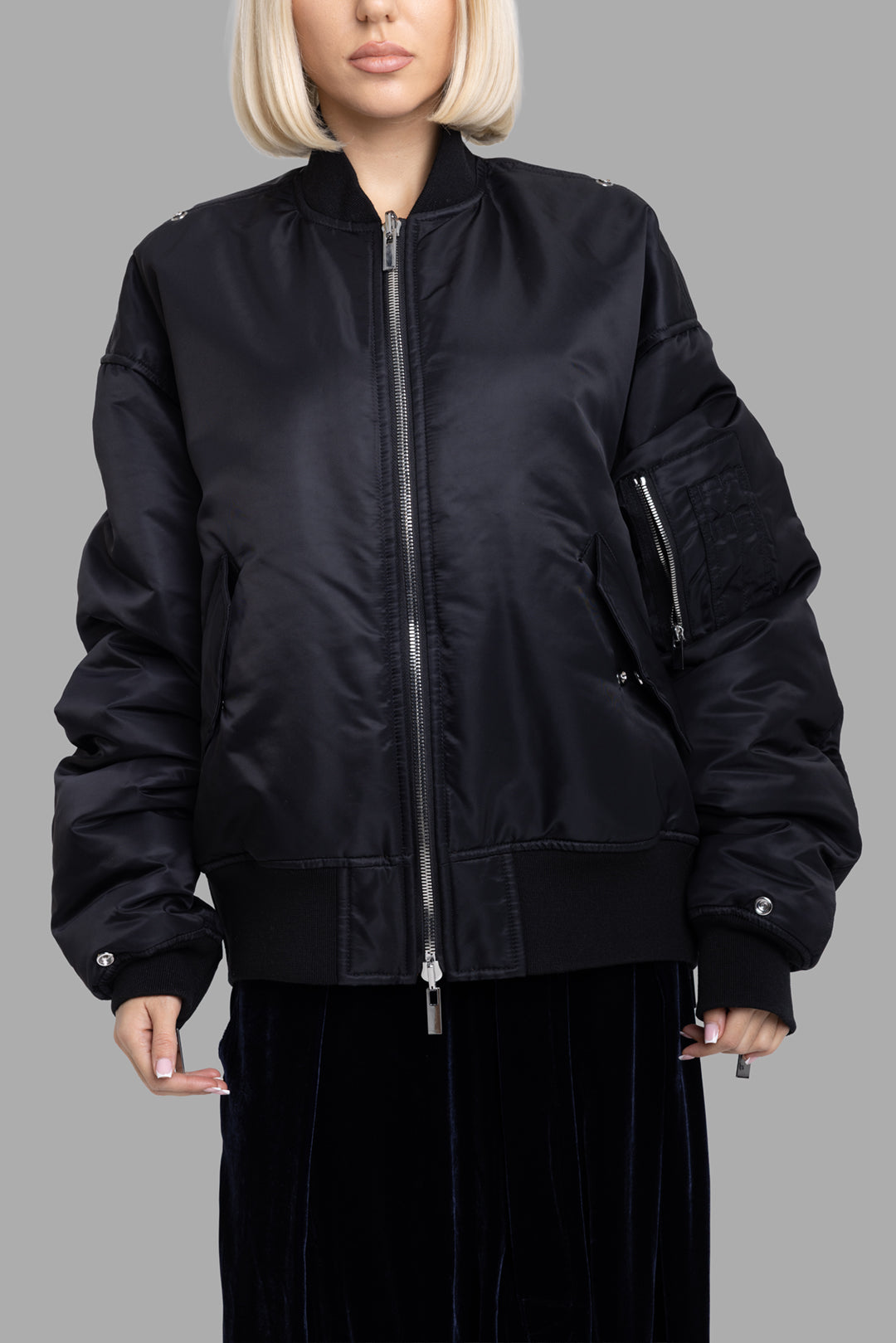 Comme des Garçons women's black bomber jacket, front view, two-way zip closure and slanted flap pockets.