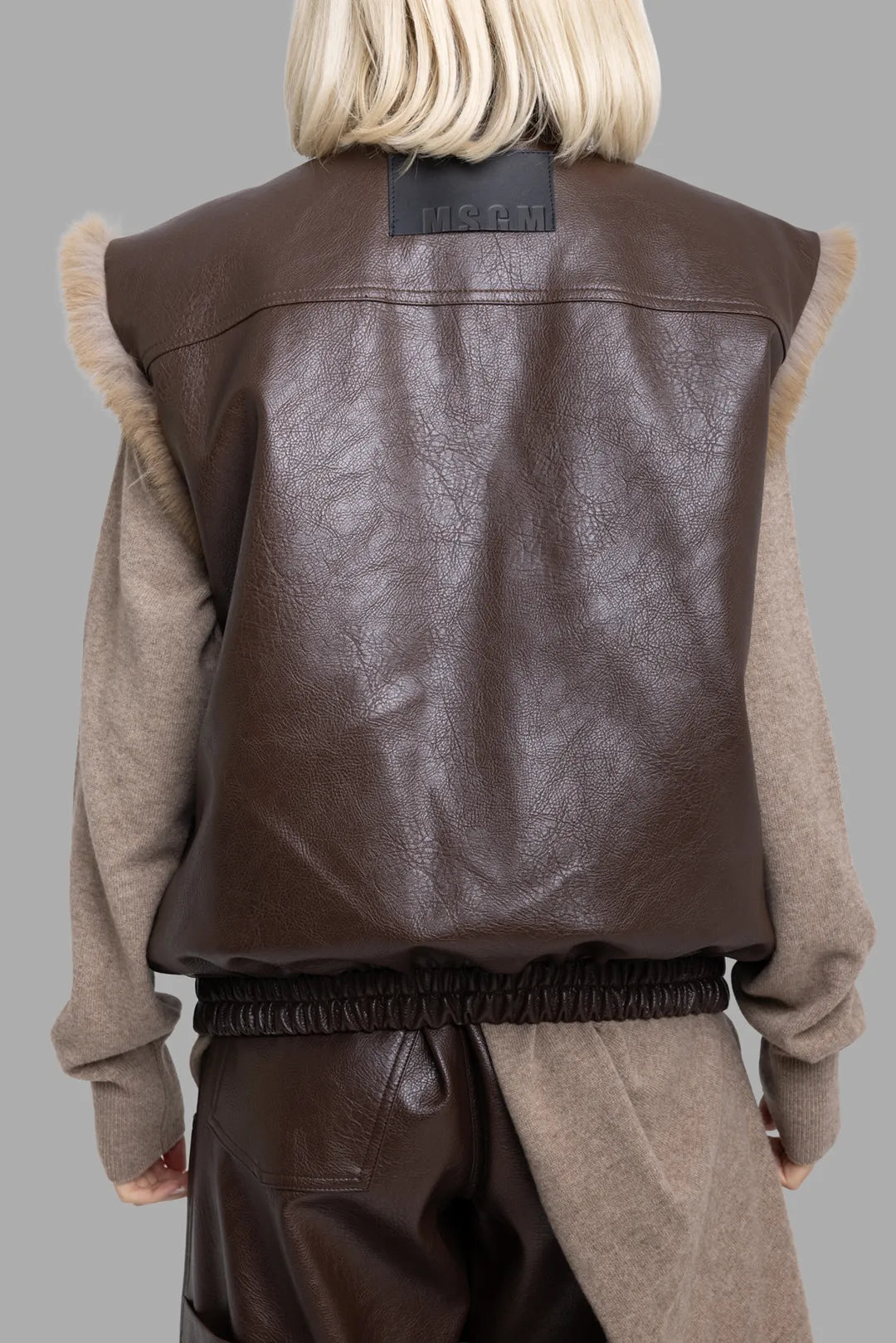 MSGM women's brown reversible faux leather vest, back view showing logo patch and gathered elastic waist.