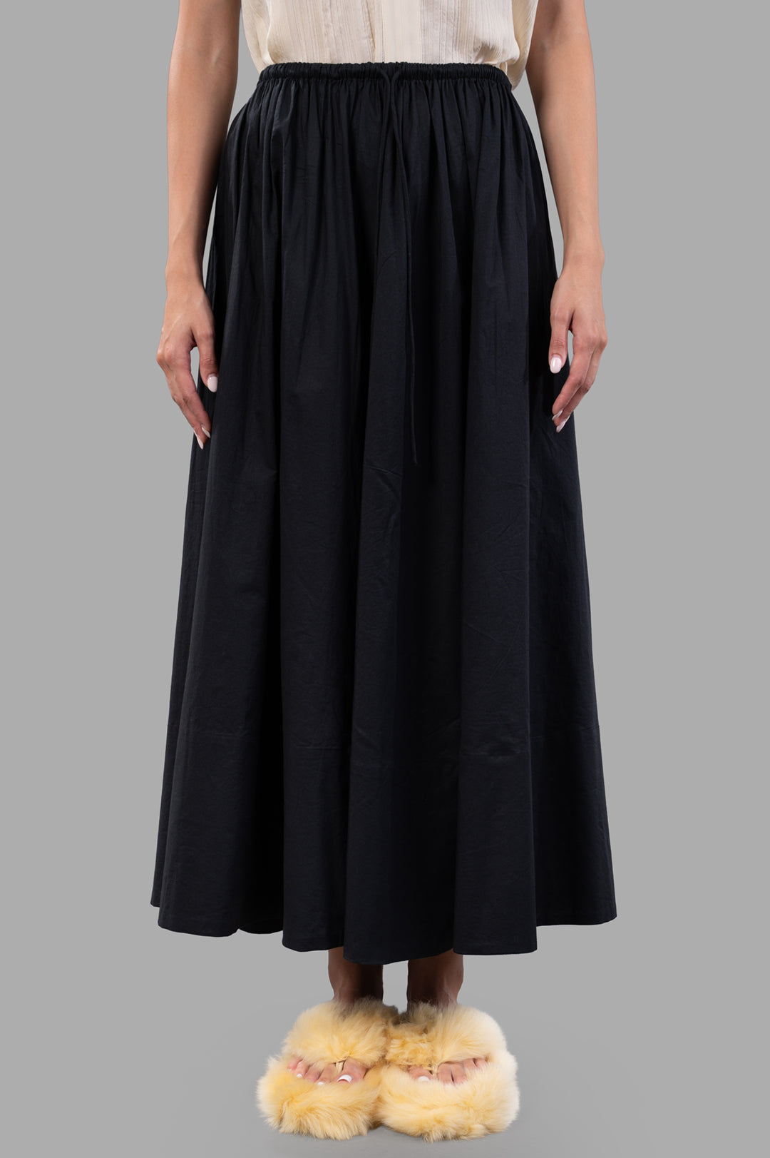 By Malene Birger Pheobes Cotton Skirt in black, featuring a high-waisted elastic band and loose silhouette, on model.