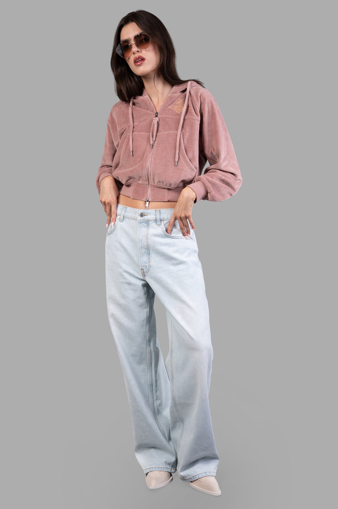 Vivienne Westwood Velvet Zip-up Hoodie on model, cropped style with drawstring, embroidered logo, paired with light jeans.