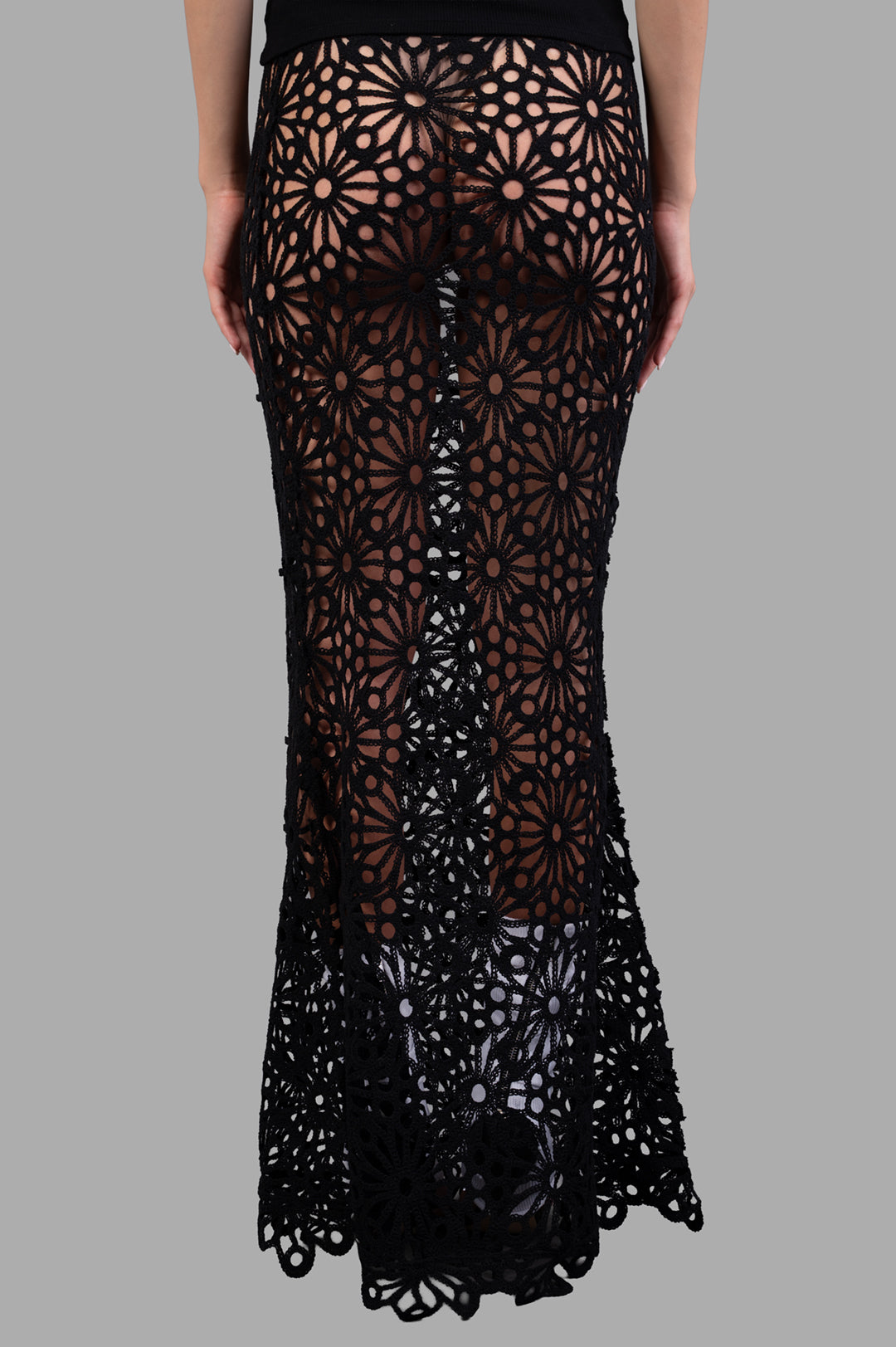 Norma Kamali Obie Long Skirt shown from the back, highlighting sheer fabric, floral details, and fishtail hem design.