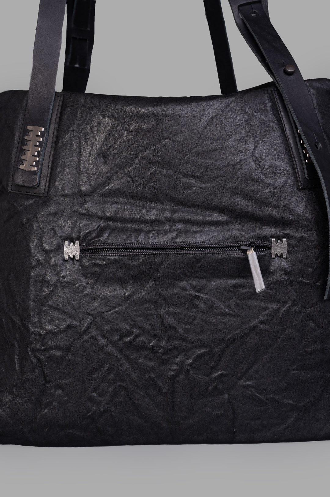 Isaac Sellam. Close-up of the Oversized Leather Bag showcasing textured crinkled black leather and functional zip pocket.