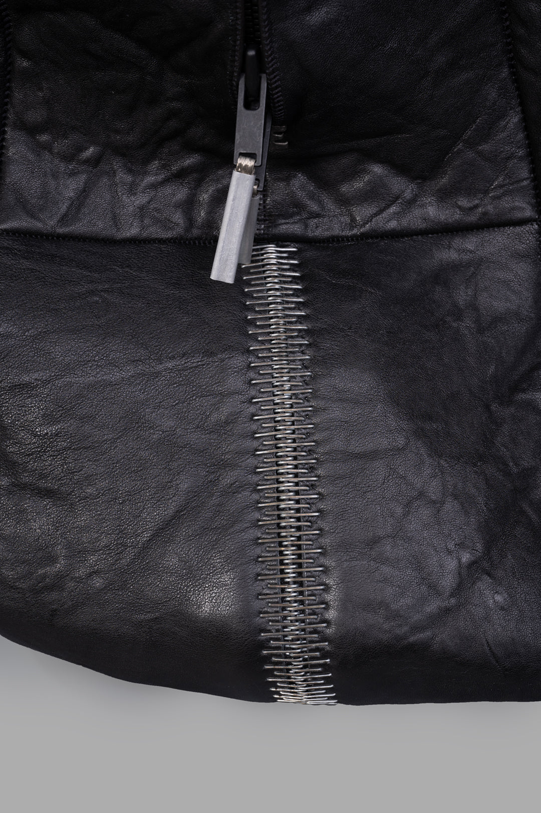 Isaac Sellam Oversized Leather Bag close-up showing durable crinkled leather and metal zipper detailing. Ideal for travel.