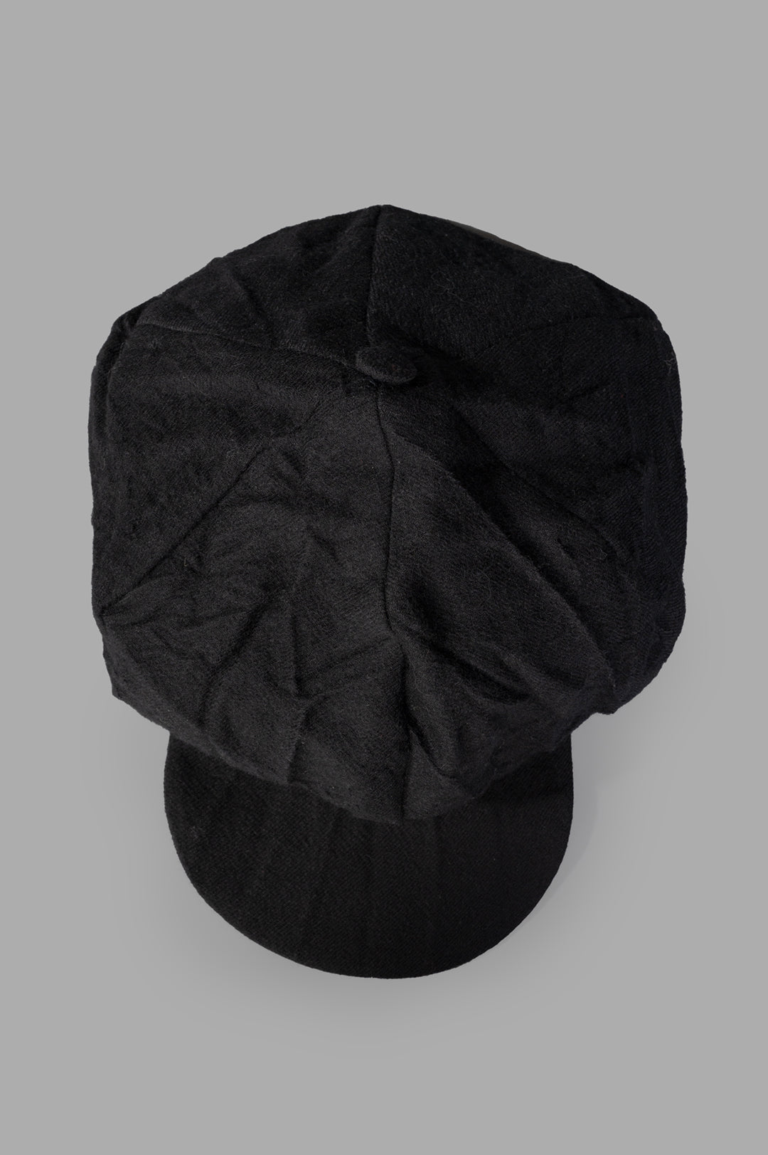 Marc Point Newsboy Cap, viewed from above, showcasing its structured top, fabric-covered button, and premium black wool.
