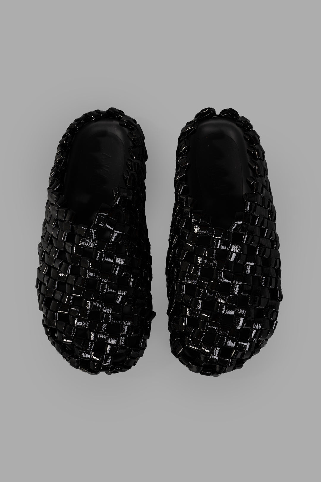 A.W.A.K.E. MODE. Weaved Clogs showcasing a stylish black woven design with a comfortable slip-on style from a top view.