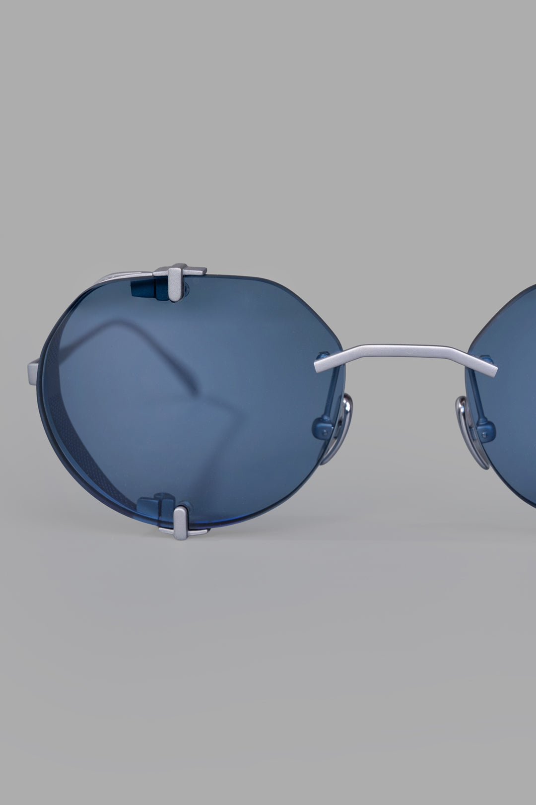 Vysen Eyewear. The Uttar - UT4 rimless titanium round frame featuring clear blue lenses and minimalist design elements.