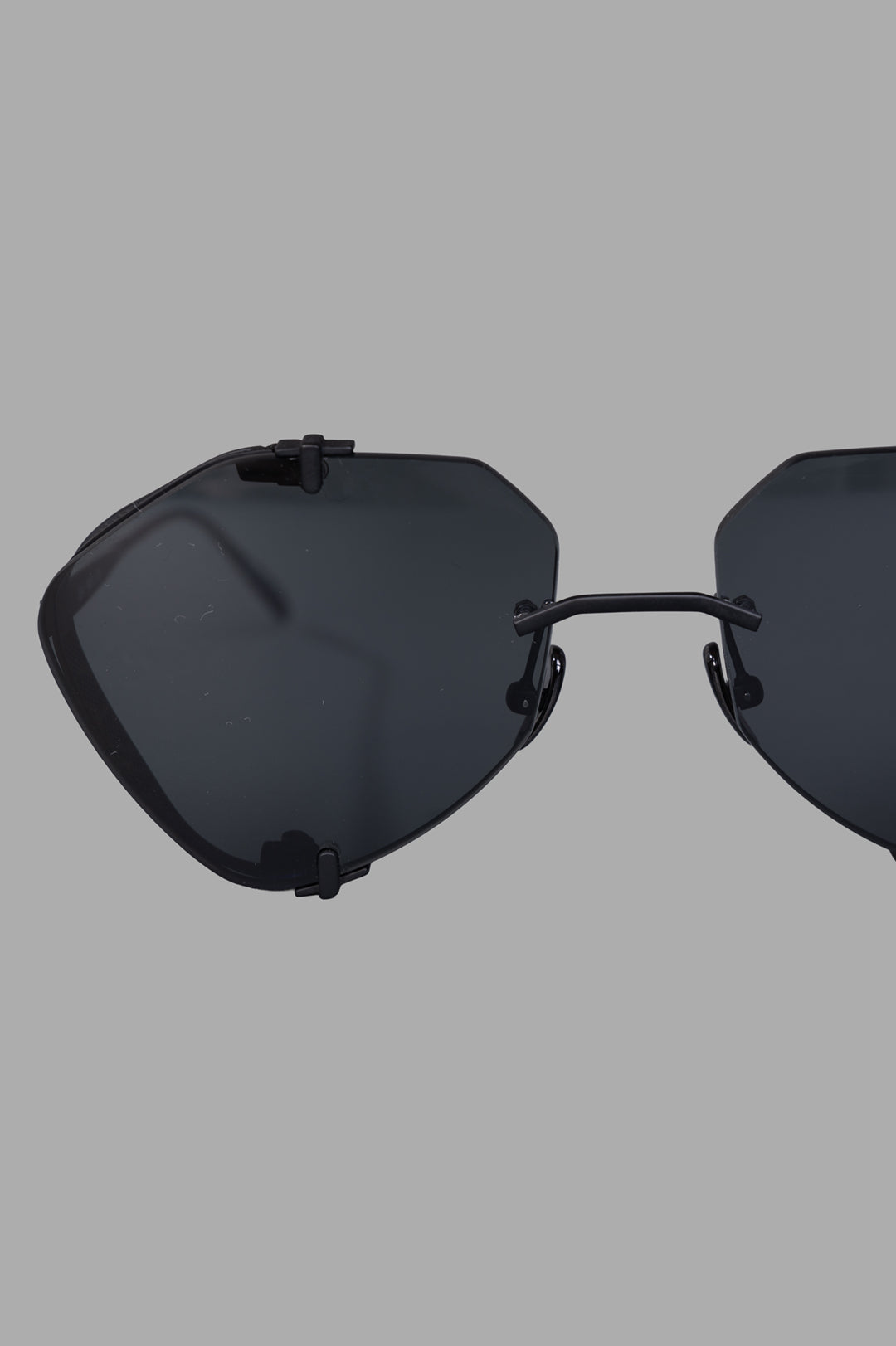 Vysen Eyewear. The Khoid - KH1 rimless titanium aviators close-up, showcasing black lenses and unique central lens anchor.