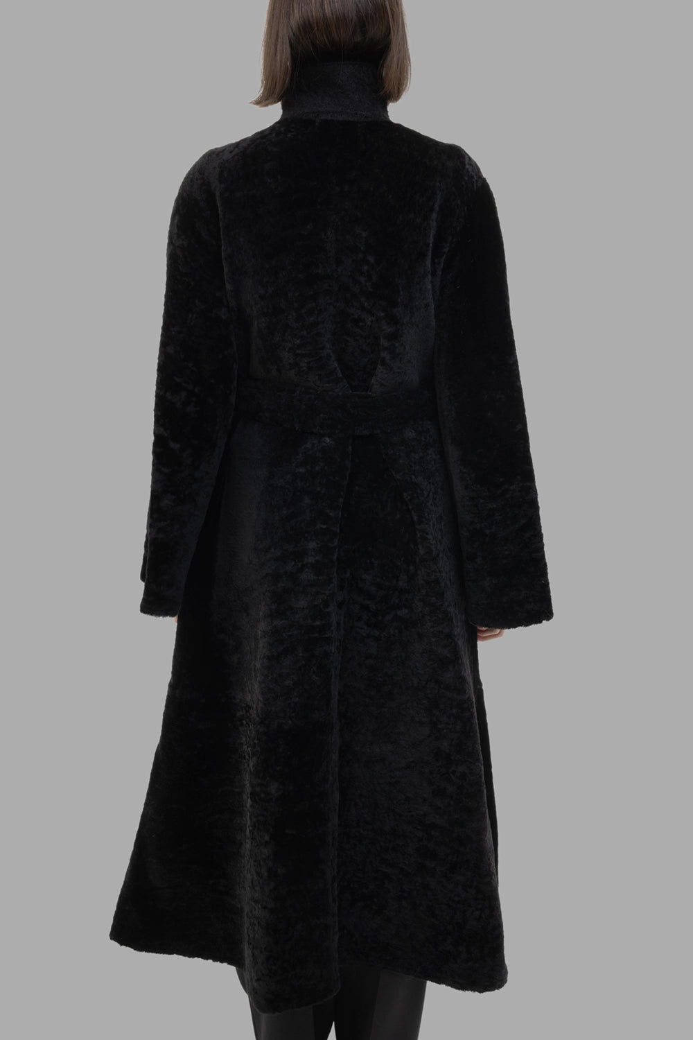 By Malene Birger women's shearling coat in black, back view, stand collar and longline hem
