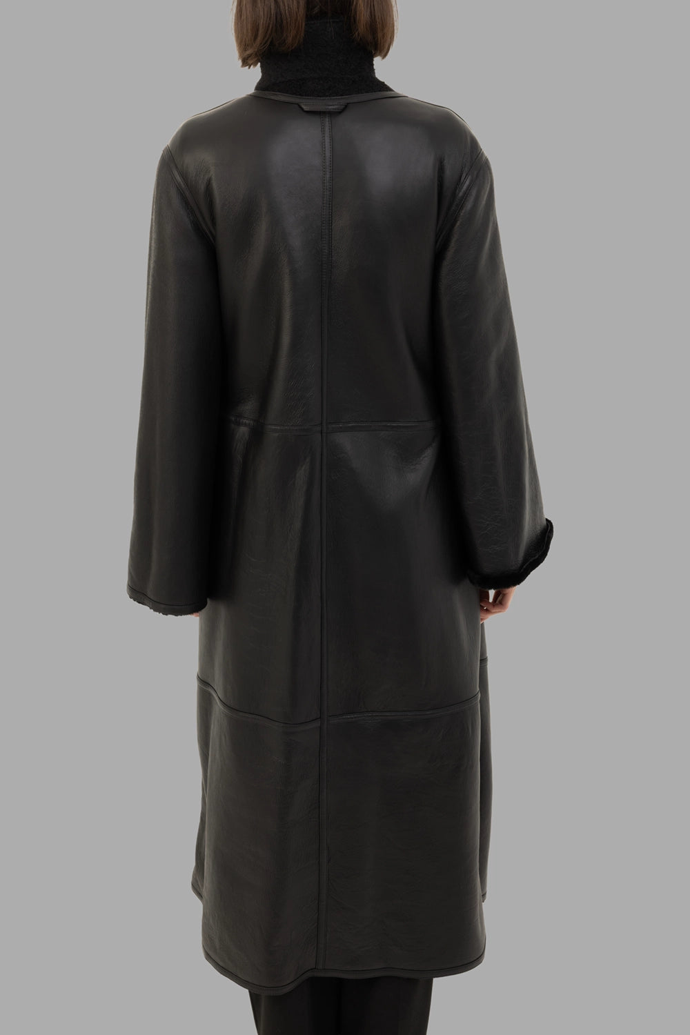 By Malene Birger women's reversible shearling coat in black, back view, smooth leather panels