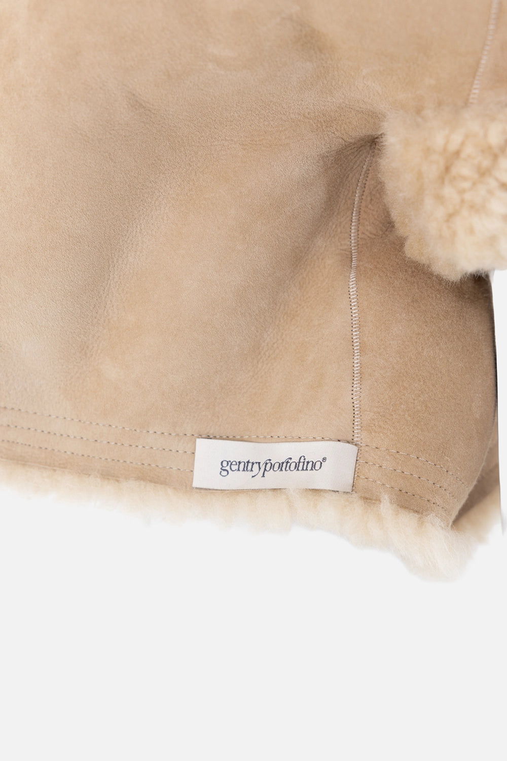 Pre-owned Gentry Portofino shearling jacket in camel, label detail view, stitched hem tag at zip edge