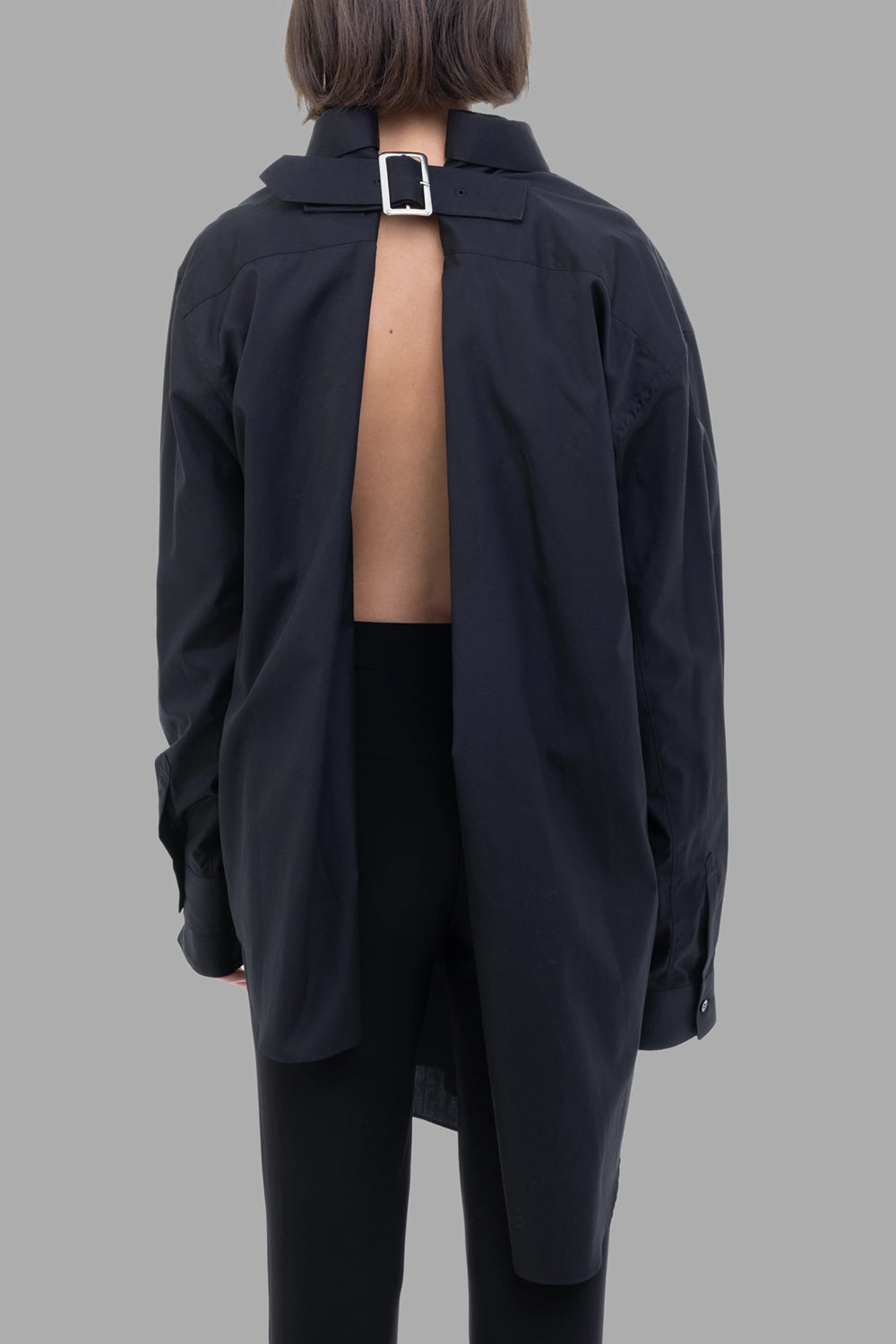 Comme des Garçons women black shirt, back view, open back with adjustable pin-buckle strap.