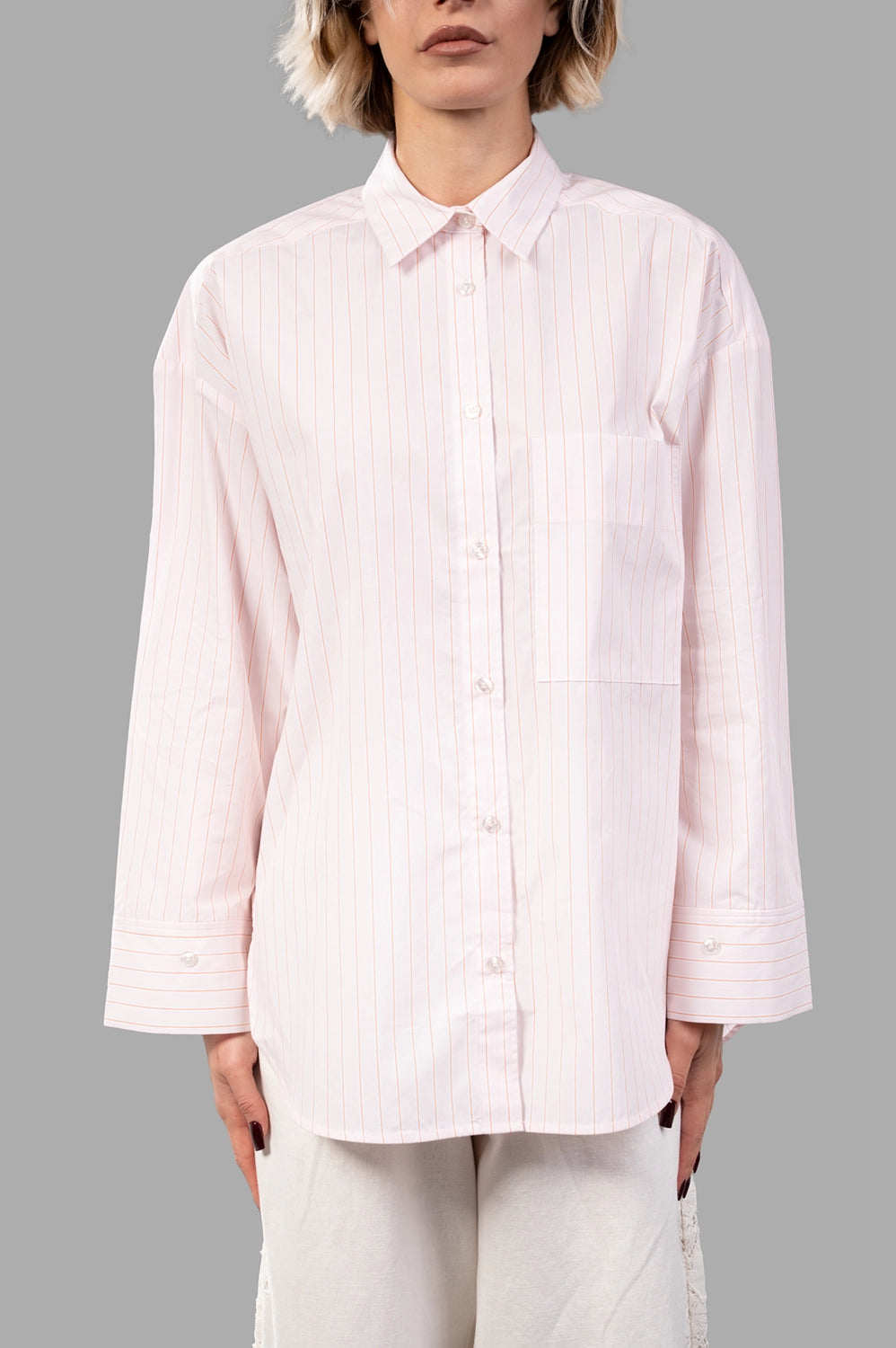 Front close-up of pink pinstripe shirt showing point collar, button placket, chest pocket
