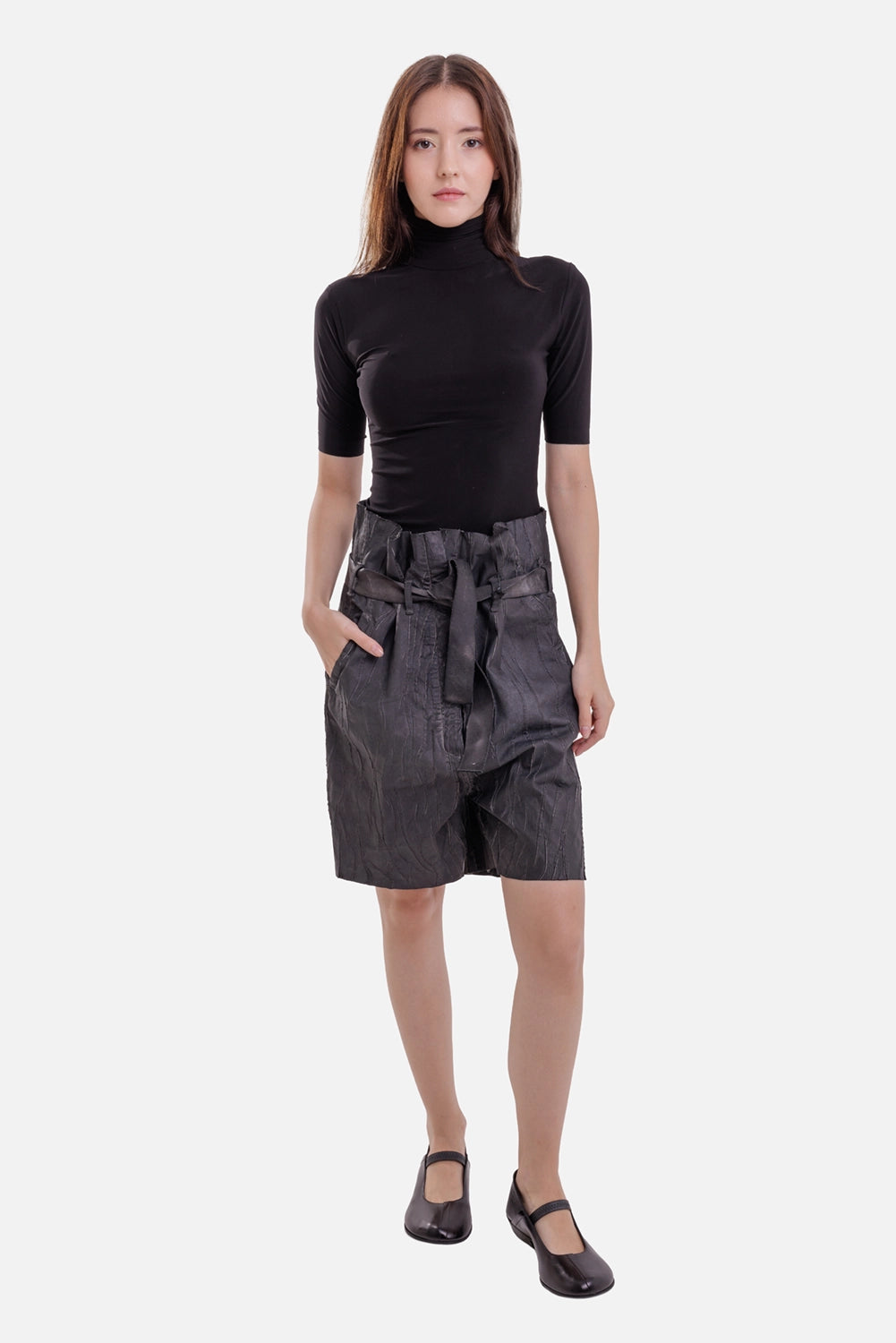Norma Kamali women's turtleneck top in black, full-length model view with slim fit and elbow-length sleeves