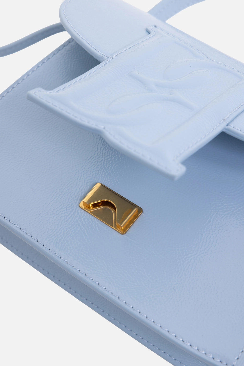 By Malene Birger women's handbag in Dream Blue, hardware close-up, raised monogram flap and gold tuck clasp