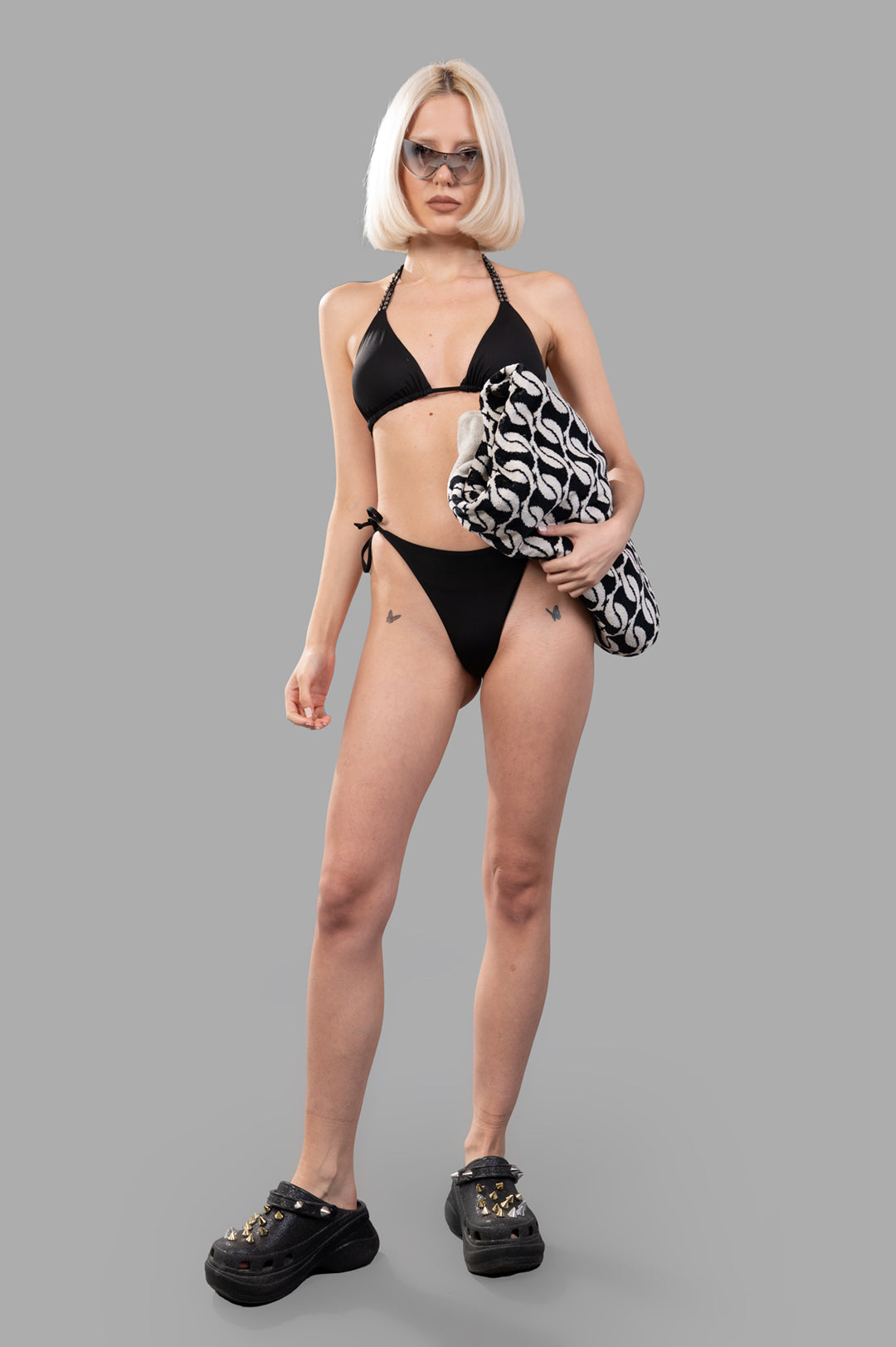 Fisico Bedazzled-strap Bikini Set, front view on-model, with halter top and side-tie bottoms, holding a patterned bag.