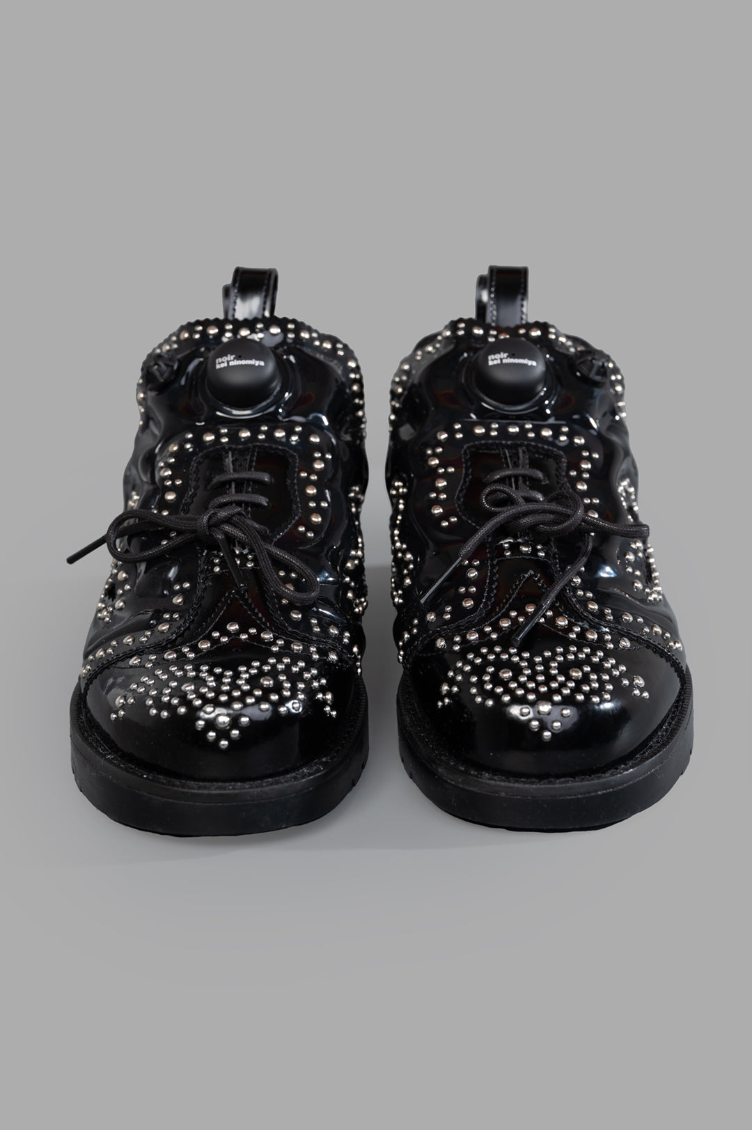 Noir Kei Ninomiya x Reebok Instapump Fury Sneakers showcase studded detailing and lace-up design, seen from the front.