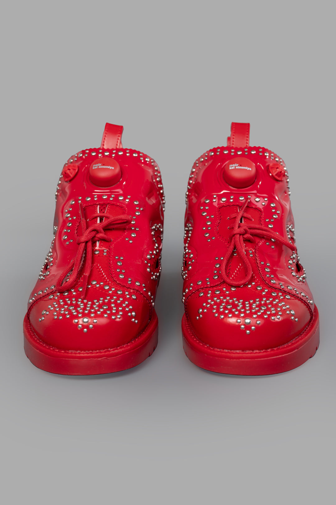 Noir Kei Ninomiya x Reebok Instapump Fury Sneakers in Red, featuring stud embellishments and lace-up detailing, front view.