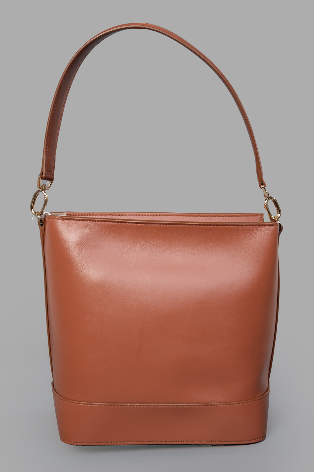 Anine Bing Lili Bucket Bag in cognac, showcasing a sleek leather design with a single shoulder strap and minimalistic style.