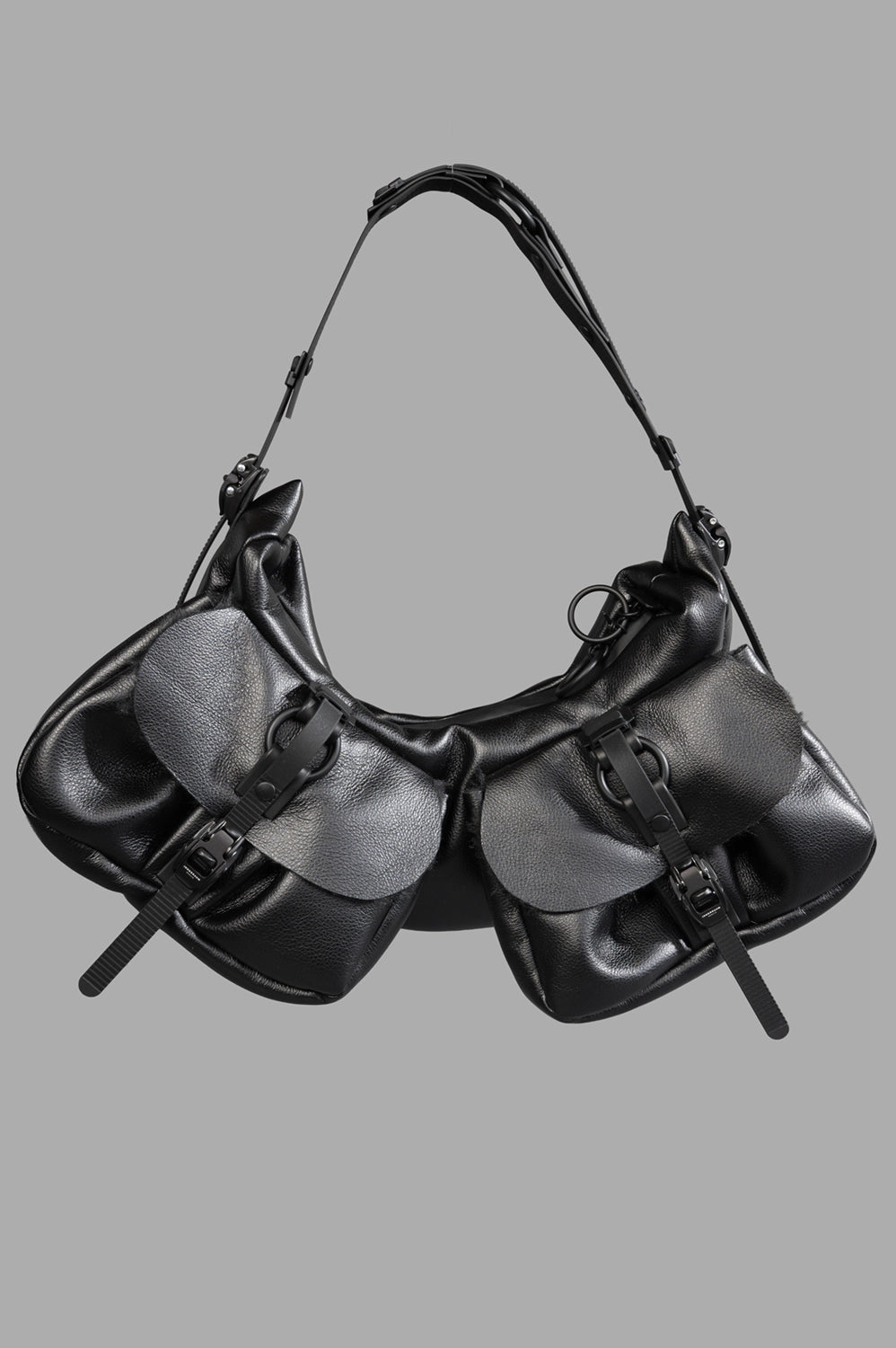Full-length product view of small half-moon bag in black matt with two front flap pockets and adjustable strap.