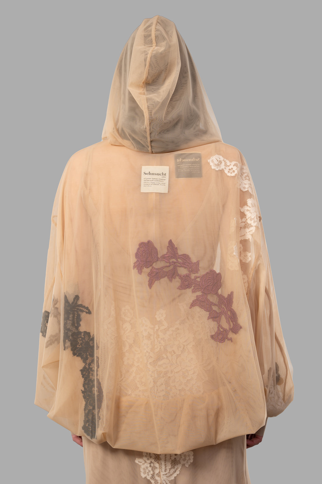 Sehnsucht Atelier. See-through Hoodie in Beige, showcasing floral lace details and a relaxed fit, viewed from the back.