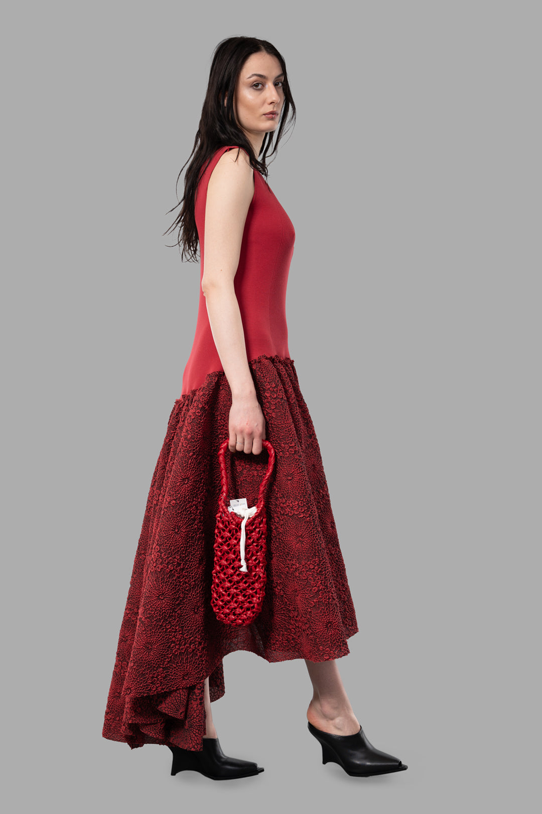 Marc Point Long Bustier Dress in Red, side view. Features maxi silhouette, asymmetrical hem, sleeveless design.