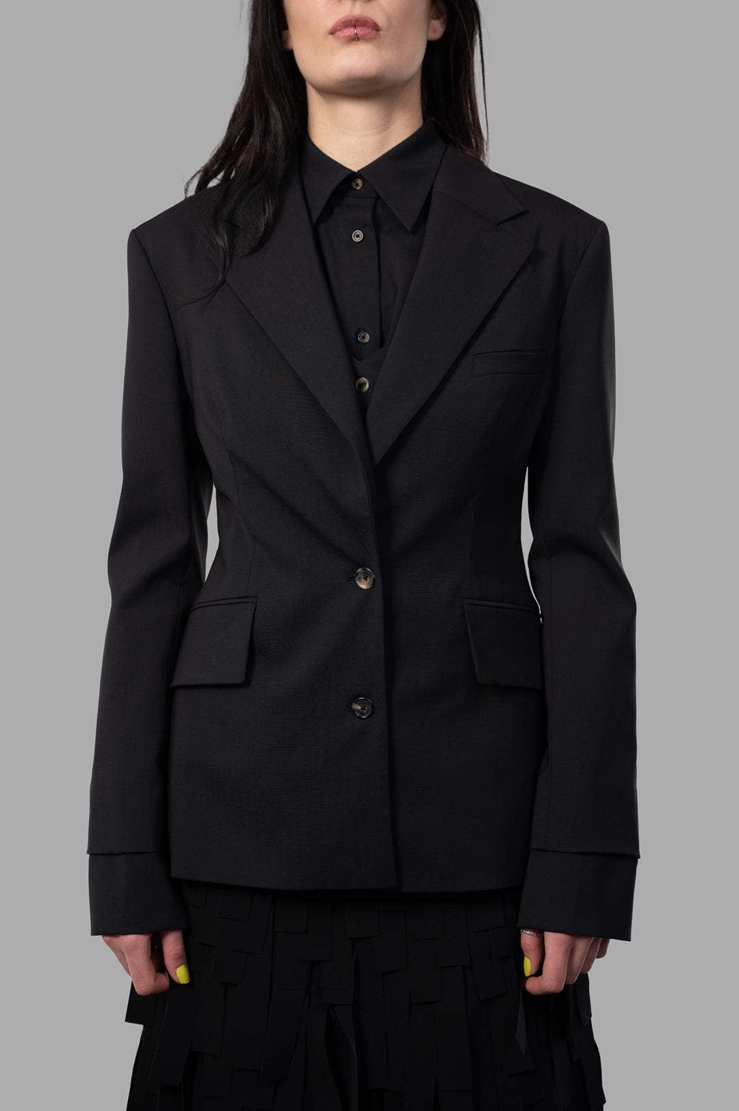 A.W.A.K.E. MODE Open-Back Blazer featuring a classic front and unique cut-out back, styled on a model in black wool blend.